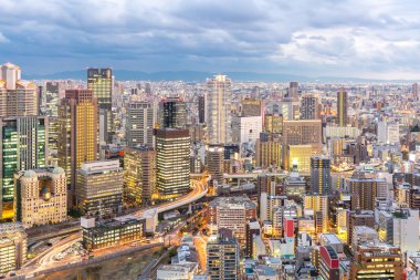 Gün batımında Osaka silüetini binalar