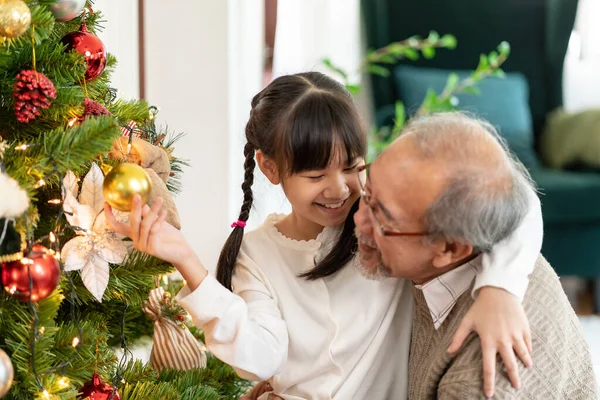 祖父と一緒にクリスマスツリーを飾る少女 彼らはクリスマスツリーを飾るメリークリスマスの季節の挨拶の準備をします 世代を超えたアジアの家族の概念 — ストック写真