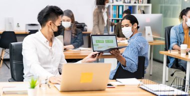 Irklar arası iş adamlarından oluşan panoramik grup maske takıyor. Yeni normal ofiste el dezenfektanı jeli ile sosyal mesafe uygulaması yaparak Coronavirus COVID-19 'un yayılmasını engelliyor.
