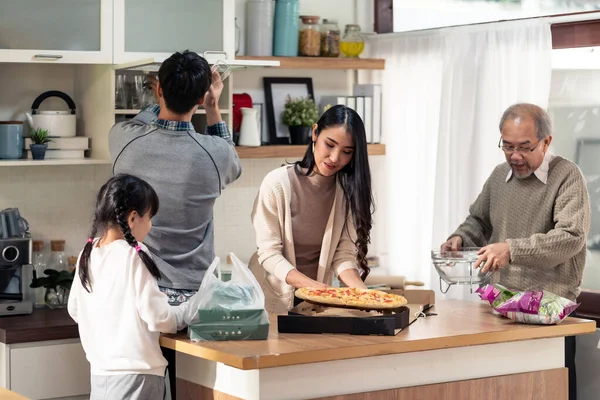 お父さんのお母さんの娘の娘と祖父の幸せなアジアの多世代家族は食事の前にダイニングテーブルを設定します 一緒に国内生活をしているアジアの幸せな家族 — ストック写真