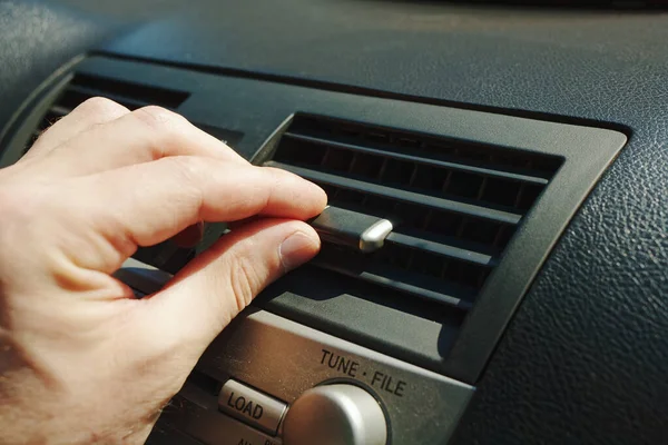 Close-up of the fan or air conditioner grilles on the car panel. A man's hand regulates the air supply to the car interior — Stock Image Close Fan Air Conditioner Grilles Car Panel Man Hand Regulates Royalty Free Stock Images