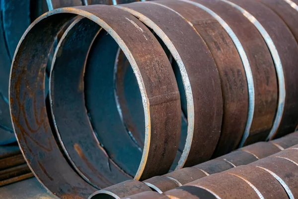 Industrial background without people. Large-diameter metal pipes are cut into rings. Procurement for repair of a pipeline