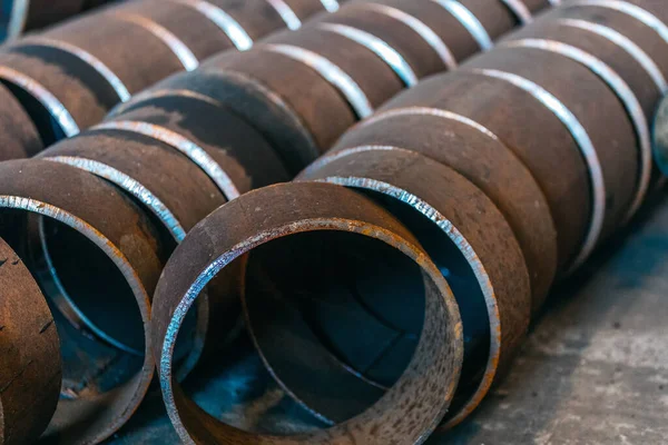 Industrial background without people. Large-diameter metal pipes are cut into rings. Procurement for repair of a pipeline