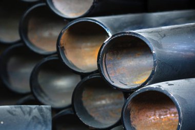 Gaz ve su tedariği için farklı çaplara sahip siyah metal borular ve adaptörler. Fotokopi alanı olan endüstriyel arka plan. Metal ürünleri için depolama