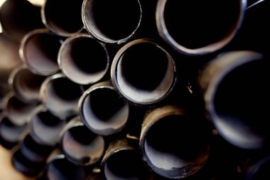 Gaz ve su tedariği için farklı çaplara sahip siyah metal borular ve adaptörler. Fotokopi alanı olan endüstriyel arka plan. Metal ürünleri için depolama