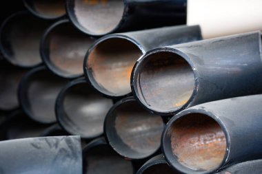 Gaz ve su tedariği için farklı çaplara sahip siyah metal borular ve adaptörler. Fotokopi alanı olan endüstriyel arka plan. Metal ürünleri için depolama