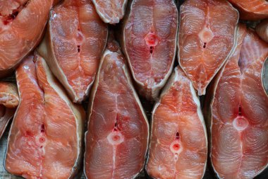 Dilimlenmiş kırmızı balık parçaları sıraya dizilir. Somon balığının soyut arkaplanı ya da yakın plan pembe somon balığı. Balık ürünleri için arkaplan