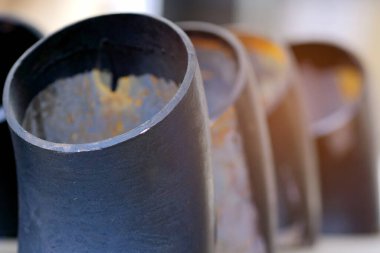 Gaz ve su tedariği için farklı çaplara sahip siyah metal borular ve adaptörler. Fotokopi alanı olan endüstriyel arka plan. Metal ürünleri için depolama