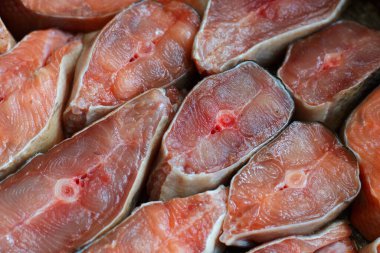 Dilimlenmiş kırmızı balık parçaları sıraya dizilir. Balık somonu ya da pembe somon balığının soyut arkaplanı.