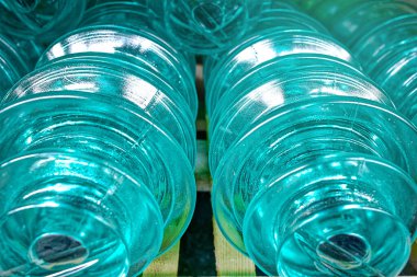 Yüksek voltajlı elektrik direkleri için cam yalıtıcılar rafta..