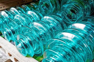 Yüksek voltajlı elektrik direkleri için cam yalıtıcılar rafta..