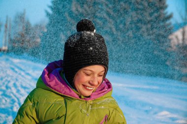 Maskesiz mutlu bir çocuk kışın yürüyüş yaparken güler ve sevinir. Güneşli bir kış gününde bir çocuğun portresi.