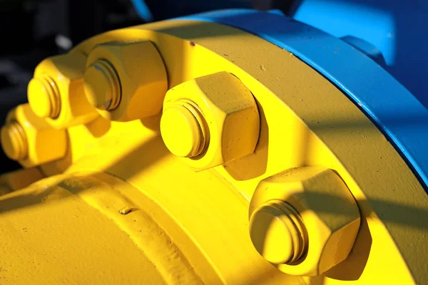 Deux conduites de gaz bleues et jaunes sont reliées par de grands boulons et écrous. Contexte pour les fournisseurs de produits et de tuyaux de gaz. — Photo