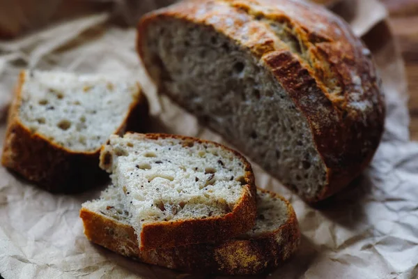 Házi készítésű kenyér gabonafélékkel, durva kézműves papíron. Finom és friss tészta saját kezűleg.. — Stock Fotó