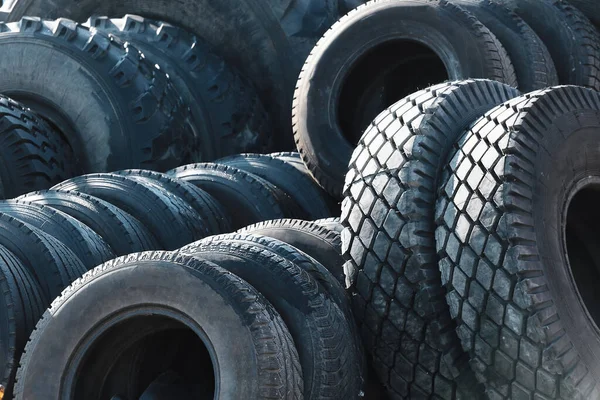 Recycling von Autoreifen für LKW. Das ist eine Menge schwarzer Gummireifen, die draußen in einer offenen Lagerhalle liegen. — Stockfoto