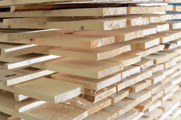 As tábuas de madeira são empilhadas em uma serraria ou carpintaria. Secagem e comercialização de madeira. — Fotografia de Stock