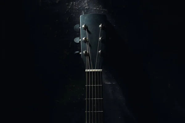 Akustik bir gitar karanlık bir arka plana karşı duvara dayanıyor. Arkaplan — Stok fotoğraf