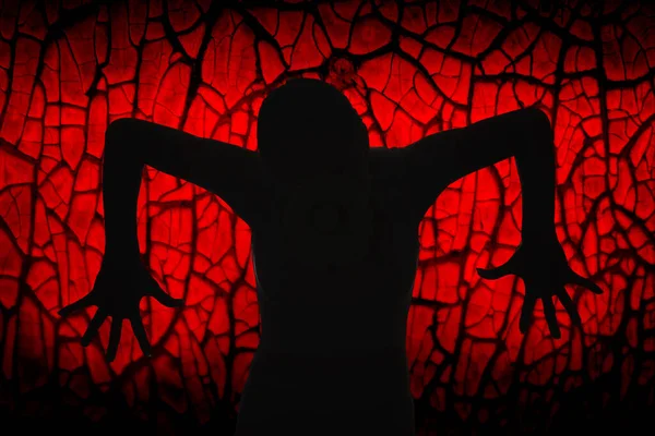 Una silueta negra de una bruja malvada y aterradora con los dedos extendidos sobre un fondo rojo brillante. — Foto de Stock