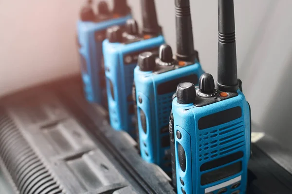 Un conjunto de walkie-talkies azules están en una fila. Dispositivo para transmitir comunicaciones de radio estables a distancia. — Foto de Stock