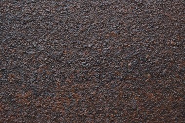 Eski, paslı, koyu renkli metal bir yüzey. Metallerin aşınması üzerindeki doku ile soyut arkaplan.