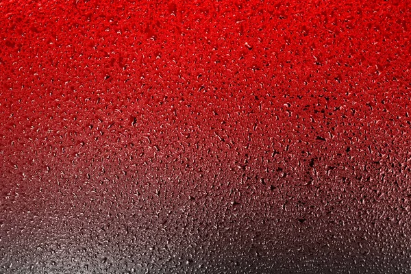 Superfície vermelha com gotas de água ou líquido com uma transição gradiente para uma cor escura. — Fotografia de Stock