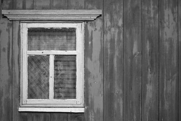 Una parete di legno con una vecchia finestra rustica. Il concetto di povertà e di fatiscenza. — Foto Stock