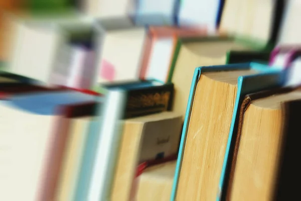 This is a lot of books standing together in several rows. Solid background of books in close-up.