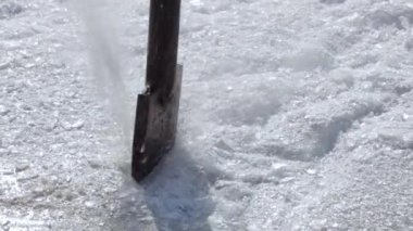 Güneşli bir günde buz yüzeyine bir metal parçası çarpar ve kristaller uçuşur..