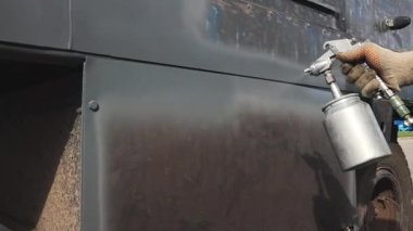 Automalyar sprey tabancadan büyük aletler boyuyor. Bir işçi yaz günü dışarıda çalışır. Profesyonel hizmet.. 