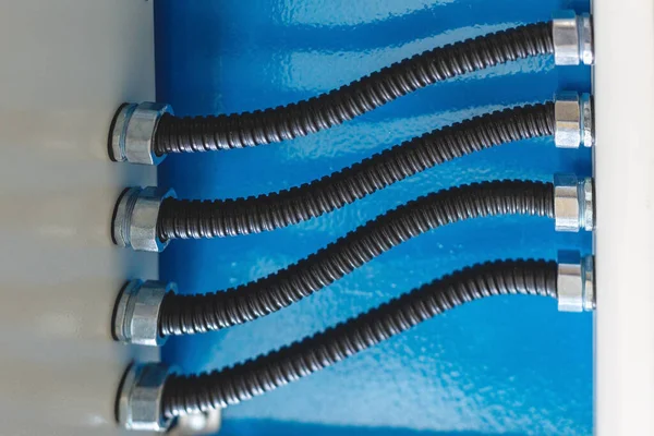 The electrical wires in the corrugated protection are attached to the cable duct by means of nuts. — Stock Photo, Image
