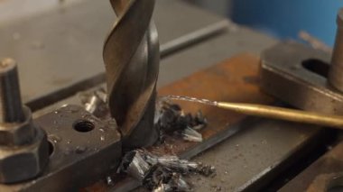 Büyük çaplı bir matkap ucu metal bir plaka deler ve metal çipler oluşur. Torna tezgahında çalışıyorum.. 