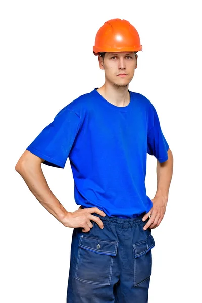 Portret van een jonge dunne arbeider in een bouwhelm en een blauw T-shirt. Een bouwer of aannemer — Stockfoto