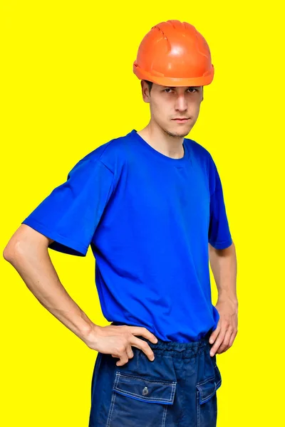 Retrato del estudio de un trabajador confiado en un casco de construcción mirando a la cámara y sosteniendo sus manos en su cinturón. — Foto de Stock