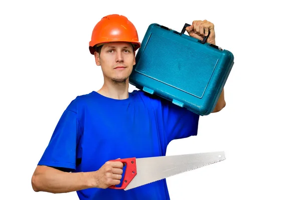 Portret van een jonge bouwer op een lichte achtergrond. Een arbeider in een bouwhelm met gereedschap in zijn handen. — Stockfoto