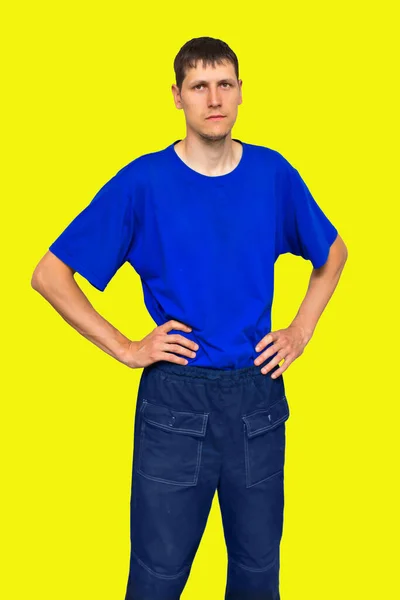 Pubblicità di abbigliamento da lavoro. Un giovane serio e sicuro di sé di aspetto caucasico.Ritratto su sfondo giallo. — Foto Stock