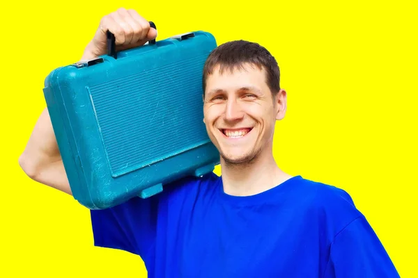 Porträtt av en positiv ung reparatör på en gul bakgrund med ett brett leende. — Stockfoto