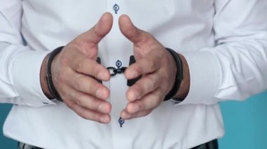 Beyaz gömlekli, kelepçeli ve mahkeme kararını bekleyen sanık.. 