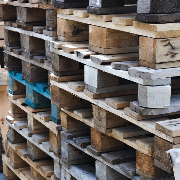 Uma pilha de paletes de madeira velhas para carregar. Logística e entrega de carga. — Fotografia de Stock