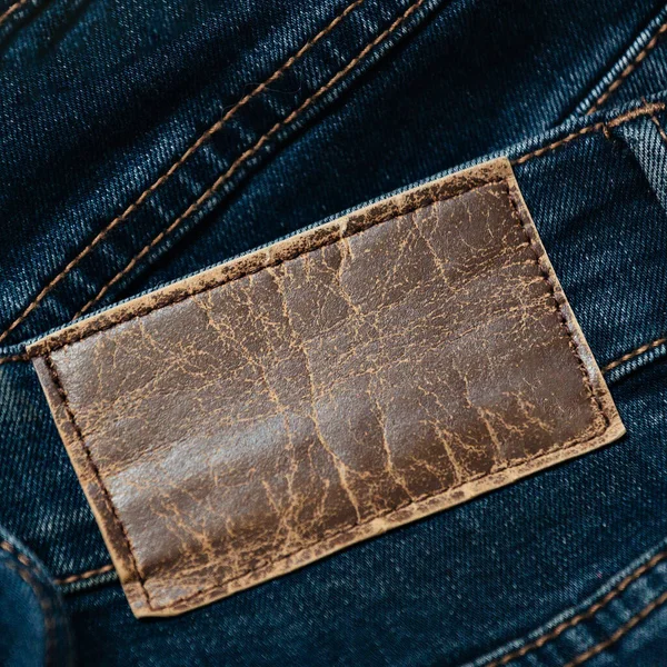 Etiqueta o etiqueta de cuero en jeans con espacio para copiar. En blanco para aplicar la información. Ropa casual. — Foto de Stock