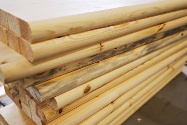 Tahtalar ve inşaat keresteleri marangozluk atölyesinde yatıyor. Ahşap işçiliği. Ürün tedarikçisinin arkaplanı.