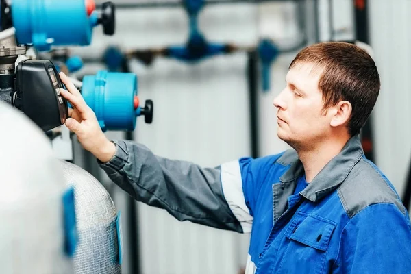 Kraftingenjören kontrollerar systemet och avläsningarna vid produktionsanläggningen inomhus. Det här är en riktig vit arbetare. — Stockfoto