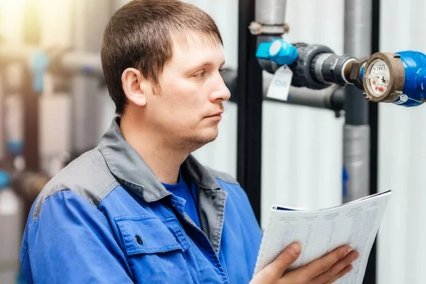 Engenheiro, trabalhador registra leituras de sensores e medidores de pressão. Controlo do abastecimento de água e do sistema de aquecimento — Fotografia de Stock