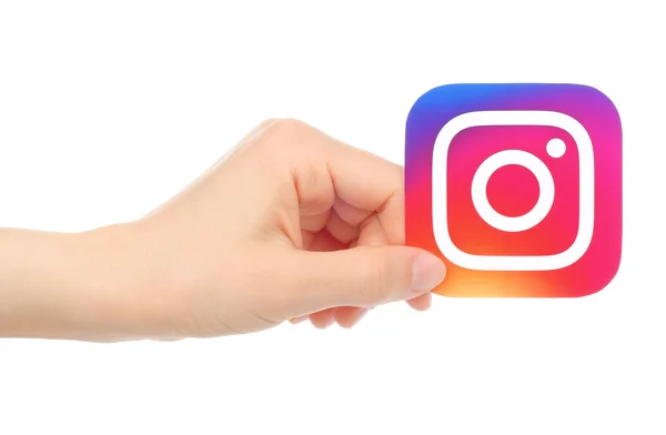 Hand holds new Instagram logo printed on paper, on white background — Stock Photo, Image