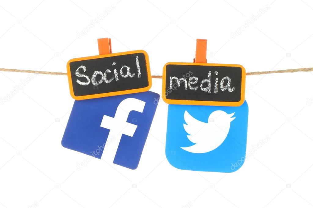 Kiev, Ukraine - August 02, 2016: Facebook and Twitter logos, printed on paper, hangind on a rope with tag orange clothespins with chalk written words 