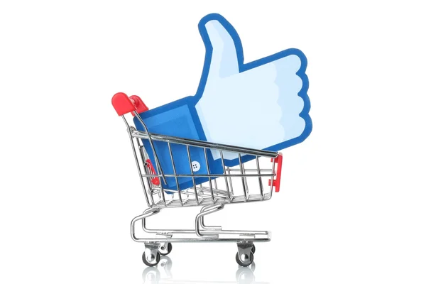 Facebook thumbs up sign printed on paper and placed into shopping cart on white background — Stock Photo, Image