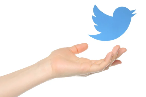 Mano con uccello Twitter stampato su carta che vola via — Foto Stock