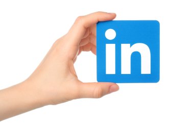 Beyaz arka plan üzerinde kağıt üzerinde yazılı LinkedIn logo işareti el tutar