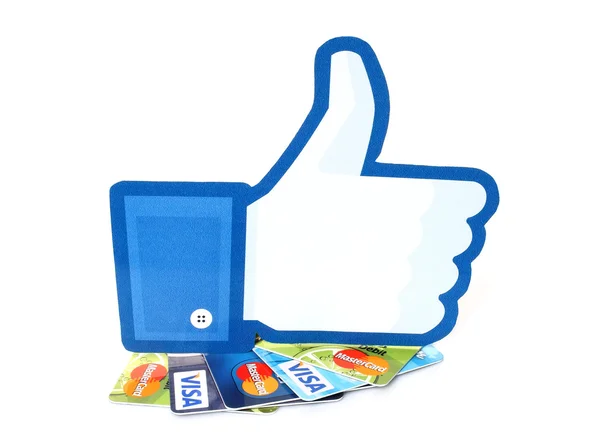 Facebook pulgares hacia arriba signo impreso en papel y colocado en tarjetas Visa y MasterCard sobre fondo blanco — Foto de Stock
