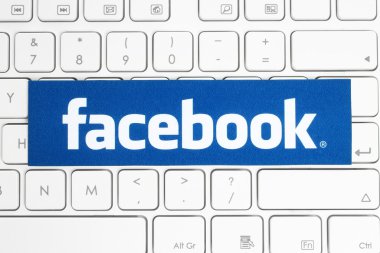 Facebook logo printed on paper and placed on white keyboard