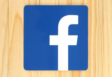 Facebook logo sign printed on paper and placed on wooden background